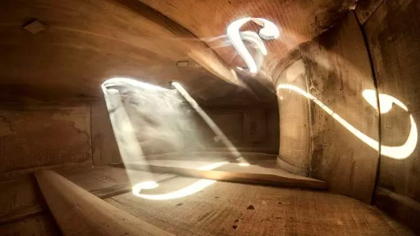 intérieur d'un violoncelle avec une lumière qui coule à à travers la poussière ambiante comme dans un lieu de culte